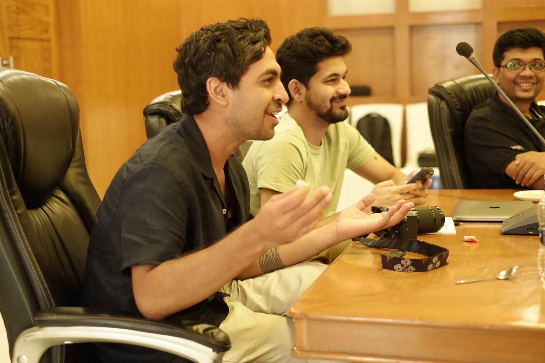 Gaurav and Ganesh in the conference room, listening and reacting with so much excitement